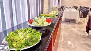 Un bufé con diversas verduras y ensaladas.
