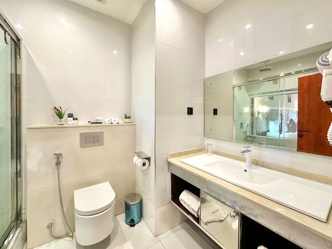A modern bathroom with a toilet, sink, and shower.