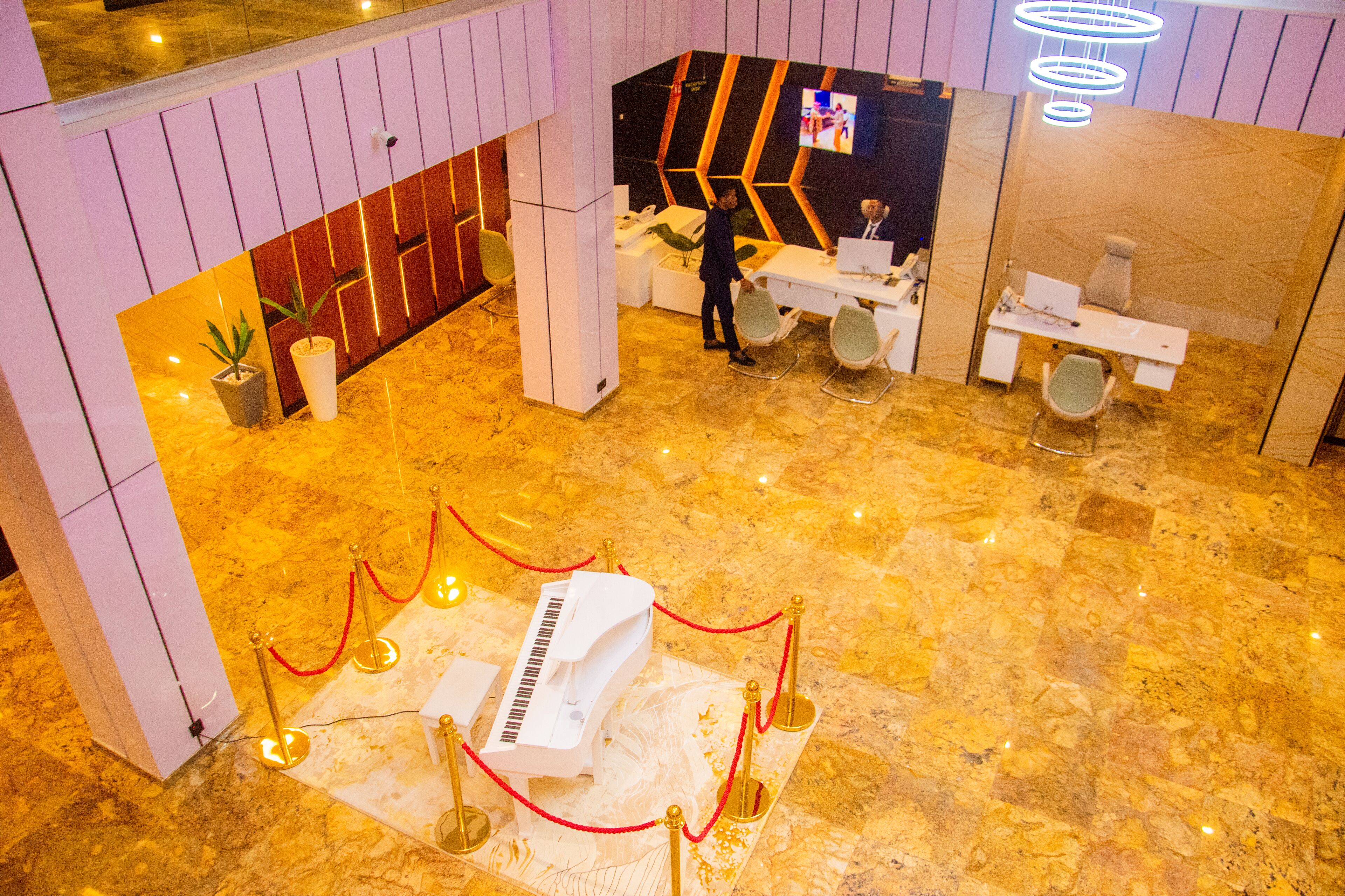 A lobby with a grand piano, a reception desk, and a modern interior design.