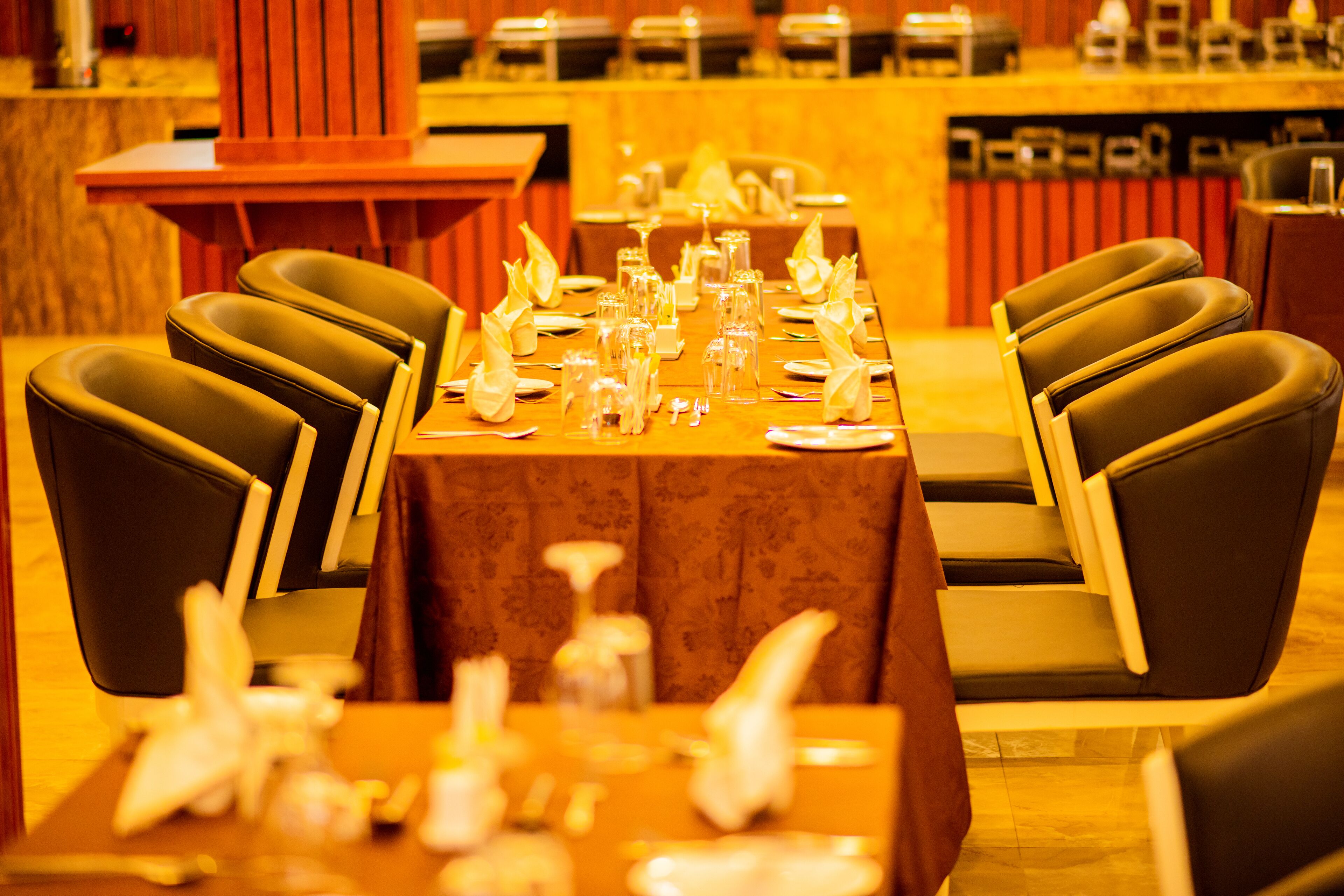 Ein Restaurant mit einem langen Tisch, der für eine Mahlzeit gedeckt ist, umgeben von Stühlen.