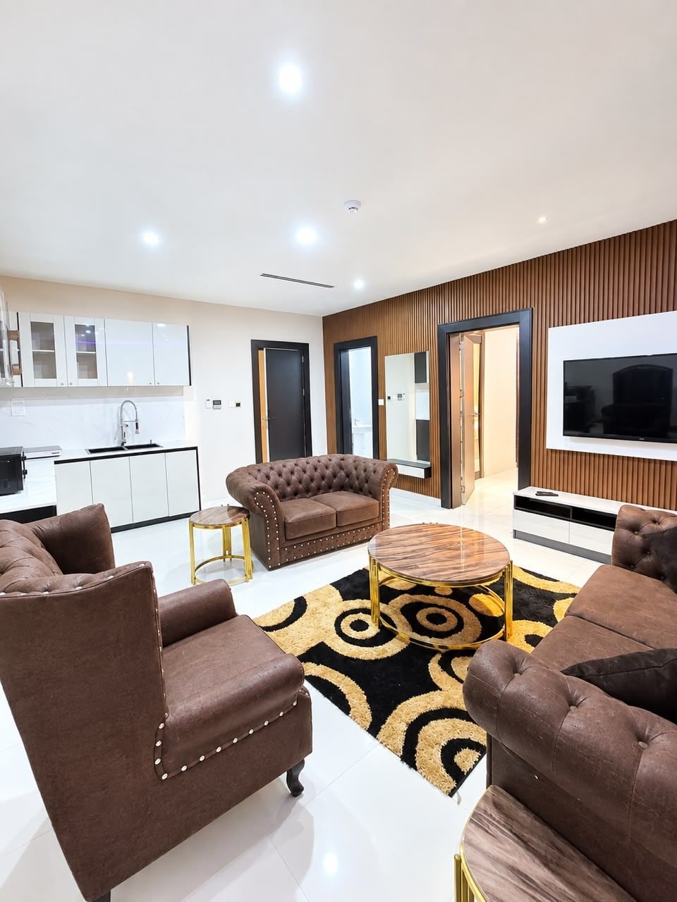 A modern living room with a sofa set, a coffee table, and a TV.