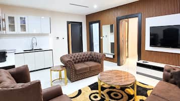 A modern living room with a sofa set, a coffee table, and a TV.