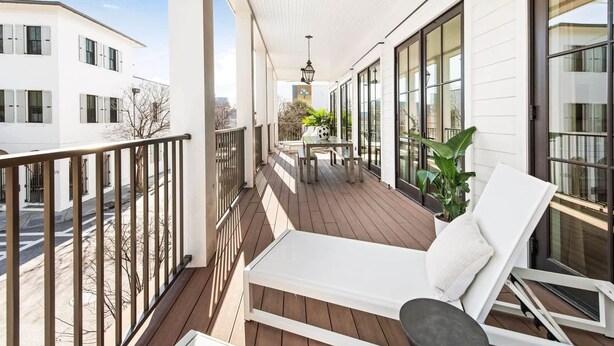 A balcony with a white sofa, a table, and a potted plant. - Newly Built, 4bd Luxury Suite steps to King! (Charleston)