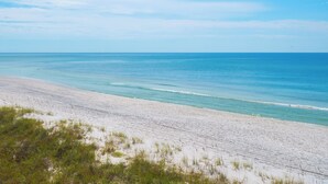 A wide sandy beach with gentle waves and a clear sky. - 🌴 Oceanfront Pinnacle Port Escape | Sleeps 8 | Last Week of July Available! (Panama City Beach)