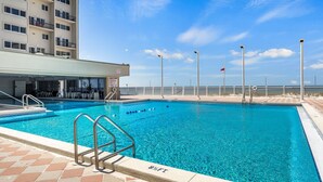A swimming pool with clear blue water, a lifeguard stand, and a view of the ocean. - 🌴 Oceanfront Pinnacle Port Escape | Sleeps 8 | Last Week of July Available! (Panama City Beach)