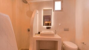 A compact bathroom with a shower, a sink, and a toilet. - The Muses of Santorini (Santorini)