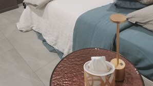A modern bedroom with a bed, a bedside table with a tissue box, and a wall-mounted TV.
