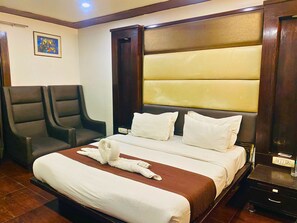 Relax in comfort with a large bed, two armchairs, and a bedside table.