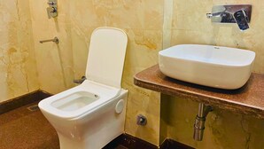 Een badkamer met toilet en wastafel.