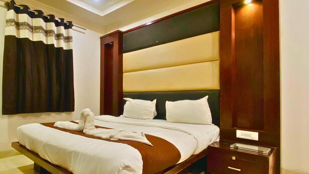 Een hotelkamer met een groot bed, een nachtkastje en een houten hoofdeinde.