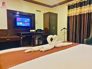 Relax in comfort with a large bed, flat-screen TV, and ample workspace.