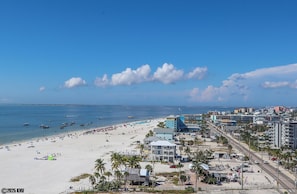 Vista de una playa con arena, océano y edificios.