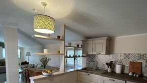 A modern kitchen with a central island, white cabinetry, and a patterned backsplash. - Casa D'ambrosio vacation Breathtaking views (Camerota)