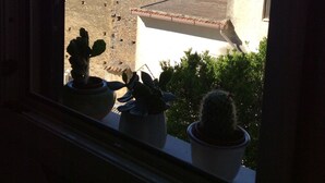 A window view of a building with a stone wall and a clear blue sky. - Casa D'ambrosio vacation Breathtaking views (Camerota)