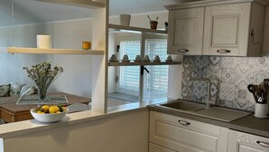 A modern kitchen with white cabinetry, a central island, and a patterned backsplash. - Casa D'ambrosio vacation Breathtaking views (Camerota)