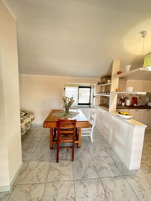 A compact living space with a dining area, kitchen, and a sofa. - Casa D'ambrosio vacation Breathtaking views (Camerota)