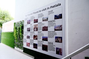 A wall with a poster listing top tourist places to visit in Patiala, including landmarks like Baradari Palace and Rajghat Hospital.