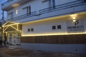 Un edificio con un cartel que dice 'Patiala Inn', con un diseño de luces geométricas sobre la entrada.