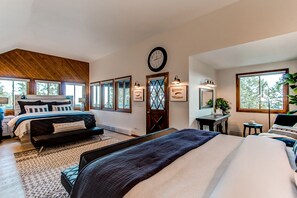 Une chambre spacieuse avec un grand lit, un petit canapé et un coin bureau.