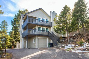 A two-story building with a balcony on the upper floor, a garage, and a staircase leading to the balcony.