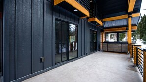 Un edificio moderno con ventanas amplias, piso de concreto y vigas de madera.