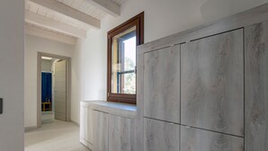A hallway with a built-in bench, a window with a wooden frame, and a door leading to another room. - Villa Ericina a two-minute walk from Tuerredda beach (Teulada)