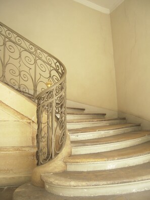 A staircase with ornate metal railings and stone steps. - QUIET NEST FOR LOVERS IN THE HEART OF PARIS! (Paris)