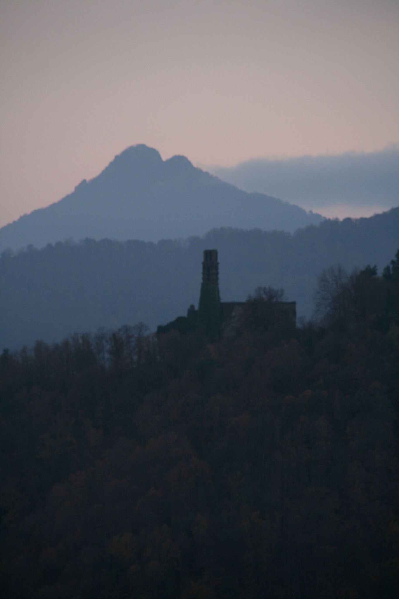 A mountain with a tower in the foreground.