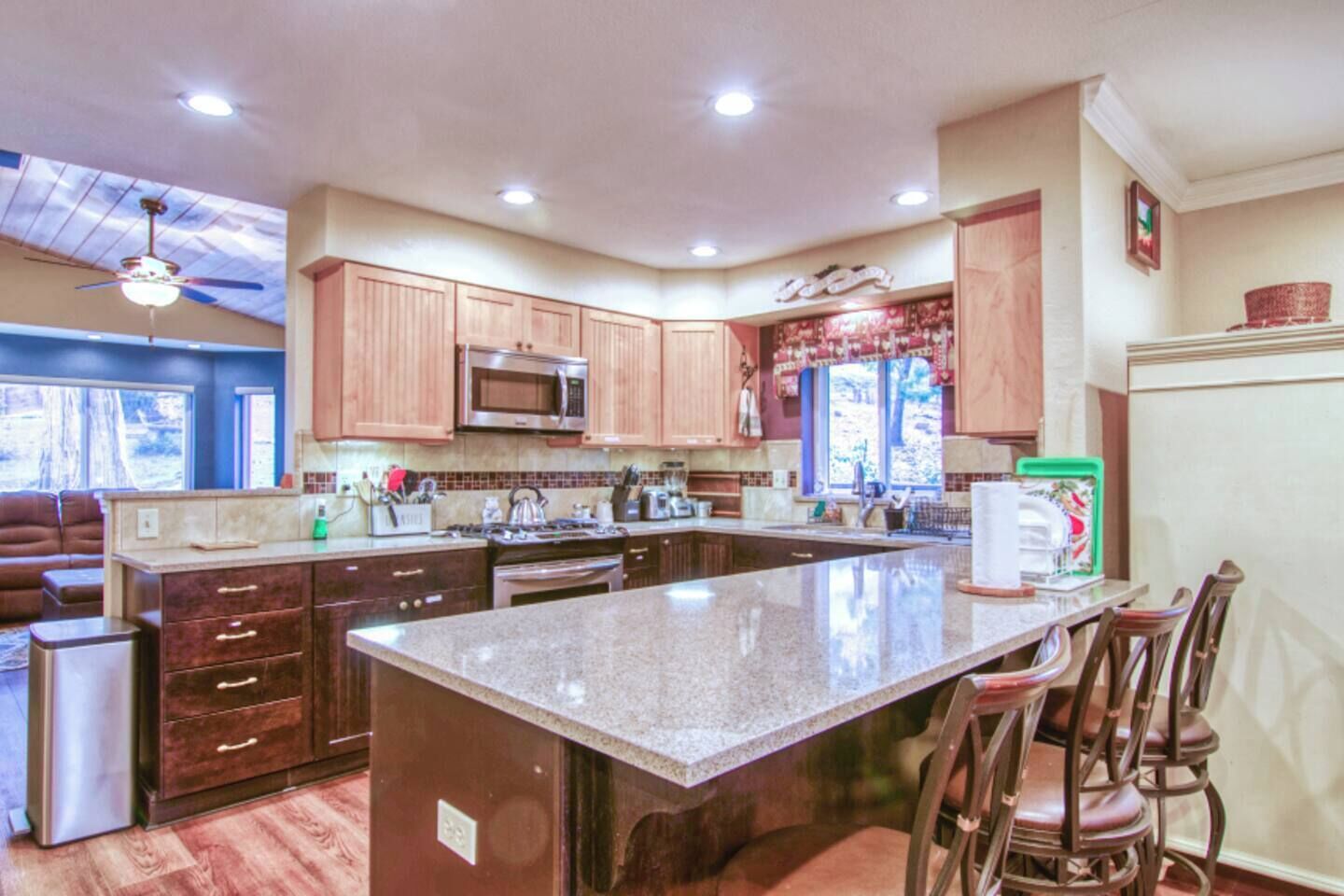 A spacious kitchen with wooden cabinets, a large island, and a microwave.
