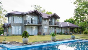 A two-story house with a swimming pool, large windows, and outdoor seating areas. - Grand Argyle Resort & Villas (Hatton)