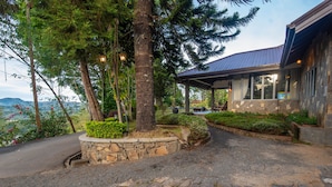 A stone pathway leading to a house with a covered porch, surrounded by lush greenery and a view of distant mountains. - Grand Argyle Resort & Villas (Hatton)