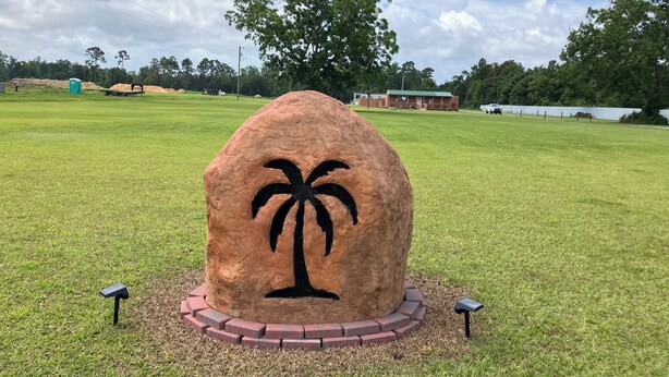 A large rock with a palm tree carving surrounded by a brick border. - Quiet Cabin with Owa theme park, shopping, dining and the beach minutes away.  (Elberta)