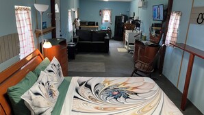A hotel room with a bed, a desk, a sofa, and a kitchenette. - Quiet Cabin with Owa theme park, shopping, dining and the beach minutes away.  (Elberta)