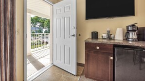 Una cocina equipada con televisor de pantalla plana, cafetera y refrigerador.