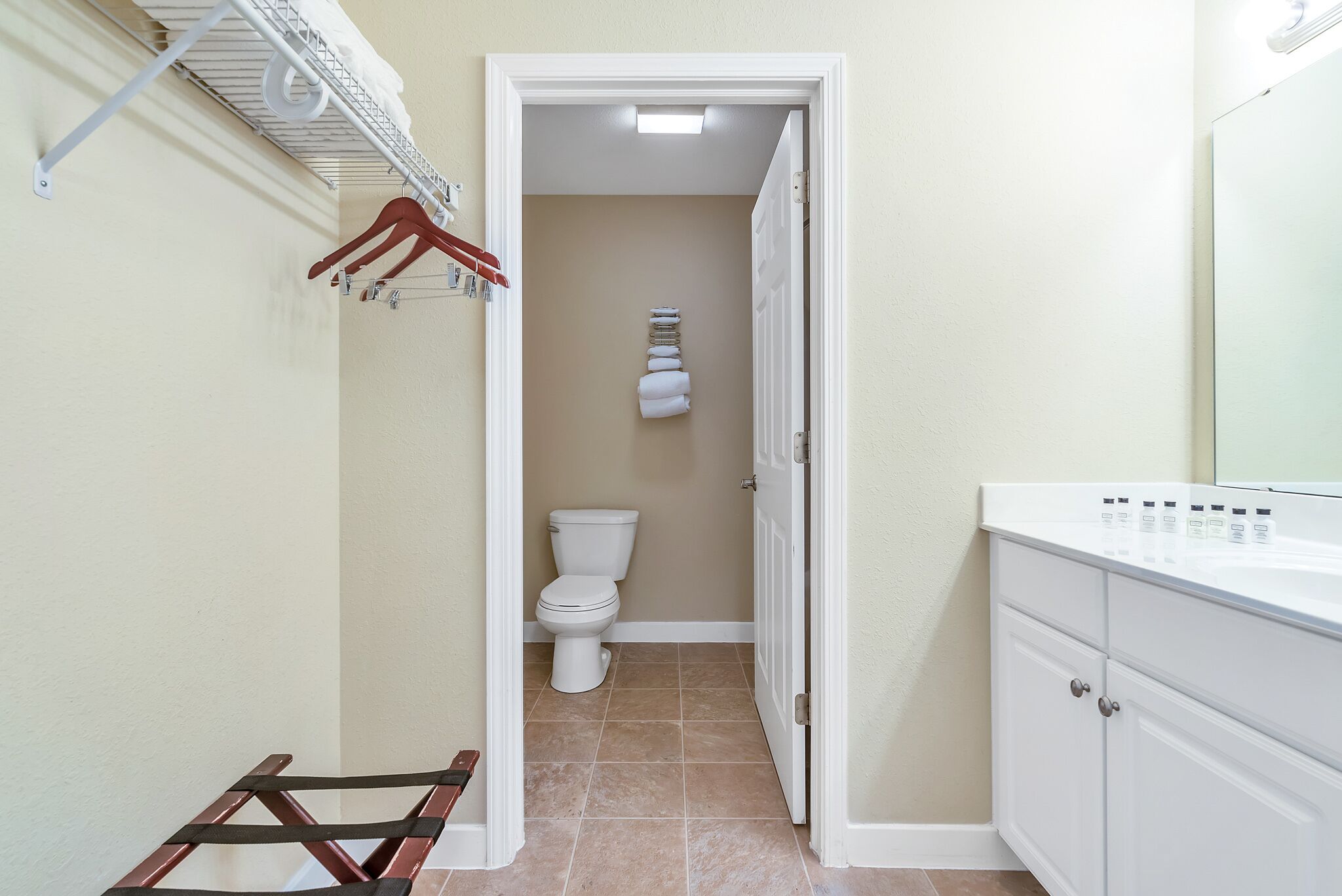 A narrow bathroom with a toilet, a towel rack, and a cabinet.
