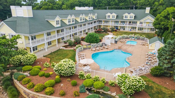 A resort with a large pool, multiple guest rooms, and a well-maintained garden.