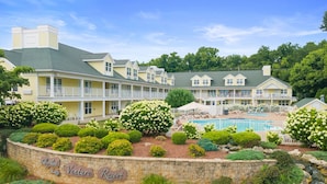A resort with a swimming pool, manicured gardens, and a brick wall with the resort's name. - ADA Glacier Suite at Kelley's Island Venture Resort (Kelleys Island)