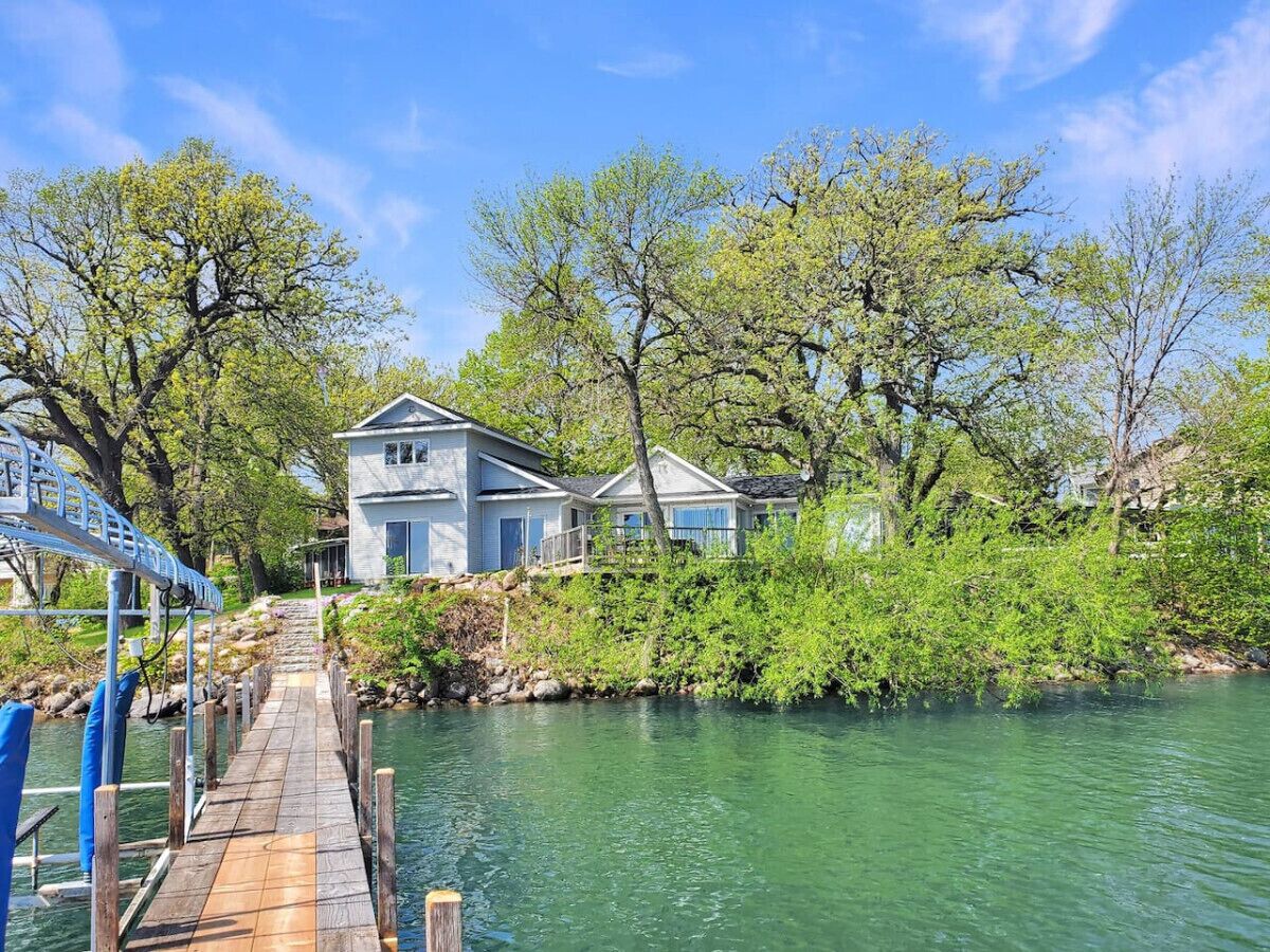 A waterfront property with a dock leading to a house.