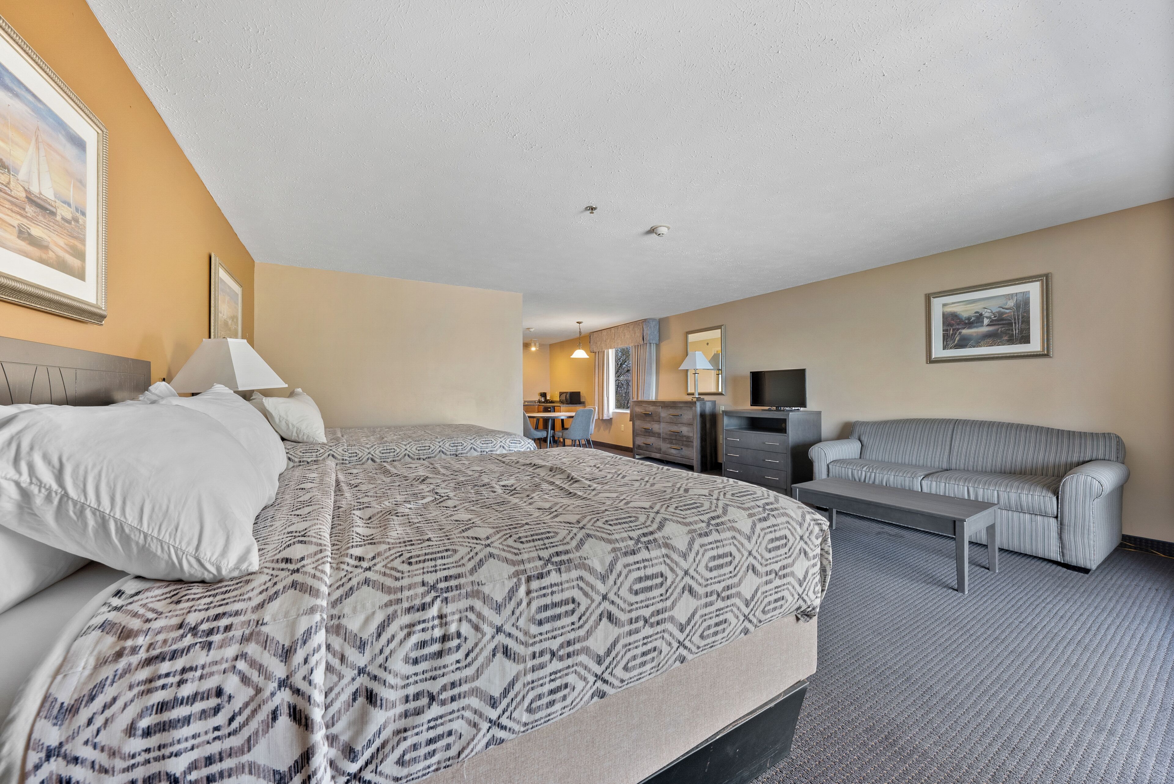 Une chambre d’hôtel avec un grand lit, un canapé, un bureau et une télévision.