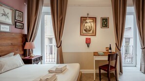 Une chambre d’hôtel avec un lit, un bureau, une chaise et une fenêtre avec des rideaux.
