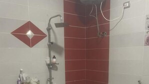 A bathroom with a large bathtub, a shower, and a toilet. - بيت عطلات (Awlad Saqr)