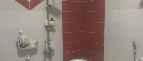 A bathroom with a large bathtub, a shower, and a toilet.