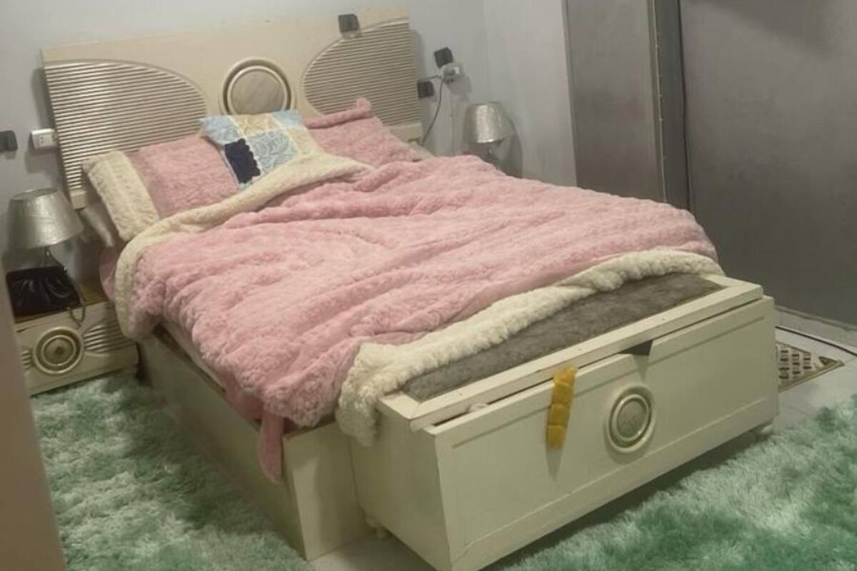 Une chambre à coucher avec un lit, une table de chevet, une lampe et une armoire.