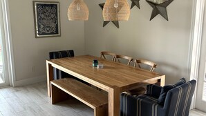 Un área de comedor con una mesa de madera, bancos y cojines a rayas.