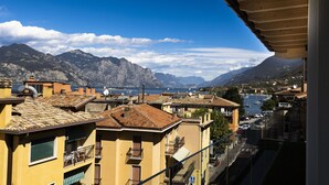 A coastal town with terracotta-roofed buildings, balconies, and a marina.
