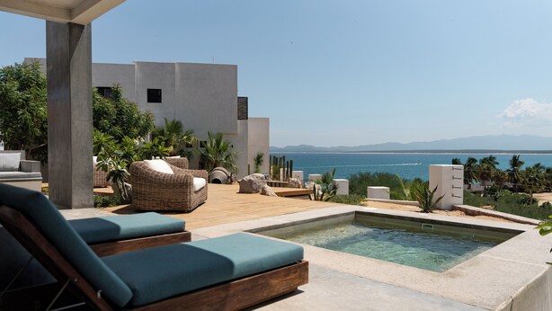 A modern outdoor pool area with lounge chairs and a view of the ocean. - 3-bedroom  w/ amazing views, waterfront access, resort amenities & hot/cold tub (El Sargento, La Ventana)