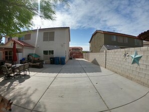 Enjoy outdoor dining and relaxation in the patio area with a dining table and comfortable seating.