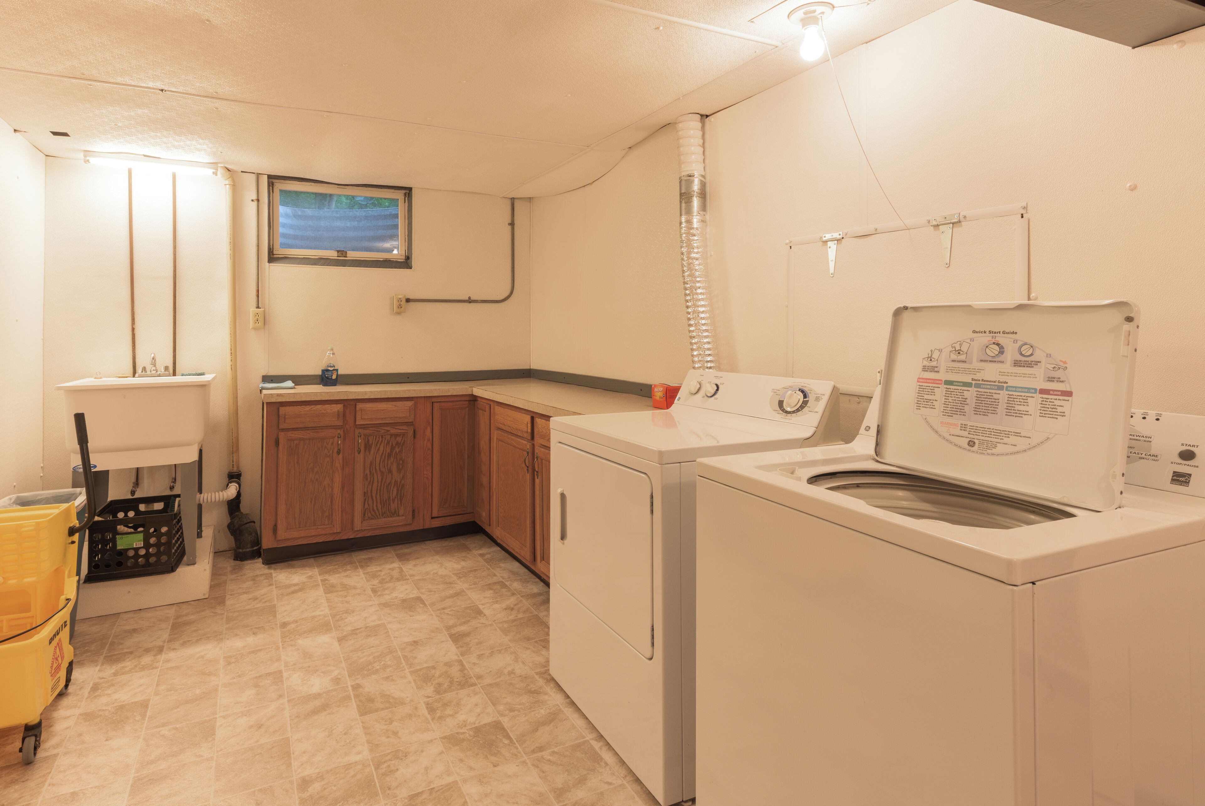 A laundry room with a washing machine, dryer, and a sink.
