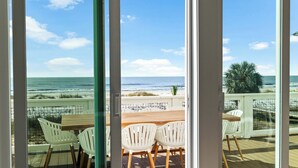 Une vue depuis une chambre dotée d’une grande fenêtre donnant sur une plage.
