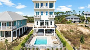 Il s’agit d’une propriété en bord de mer, composée de plusieurs étages, dotée d’une piscine, de nombreux balcons et d’un patio couvert.